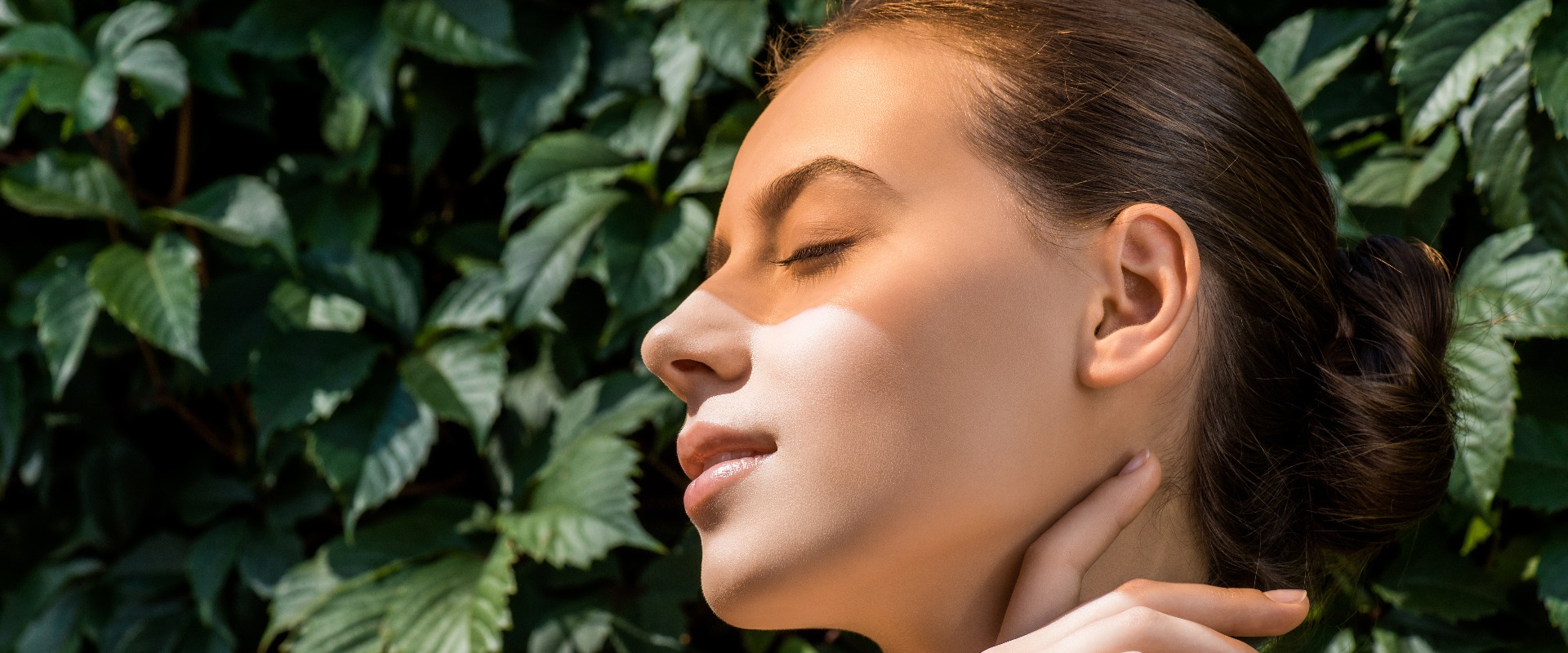 Young woman with orange shadow on face and leaves at background jpg